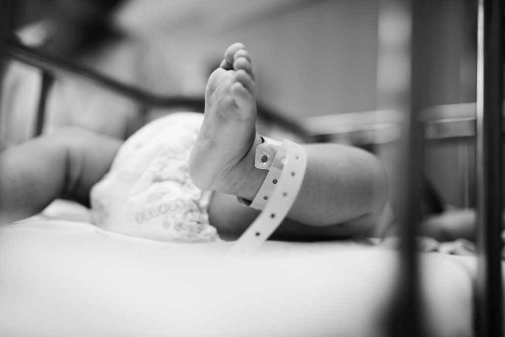 newborn baby foot with hospital baby bracelet on ankle