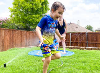 child running in sprinklers during summer when it's too hot outside