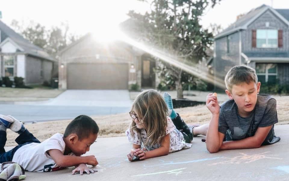 kids chalking a driveway, becoming a foster parent in Texas