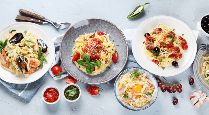A table is set with different pasta dishes from carbonara to spaghetti with mussels.