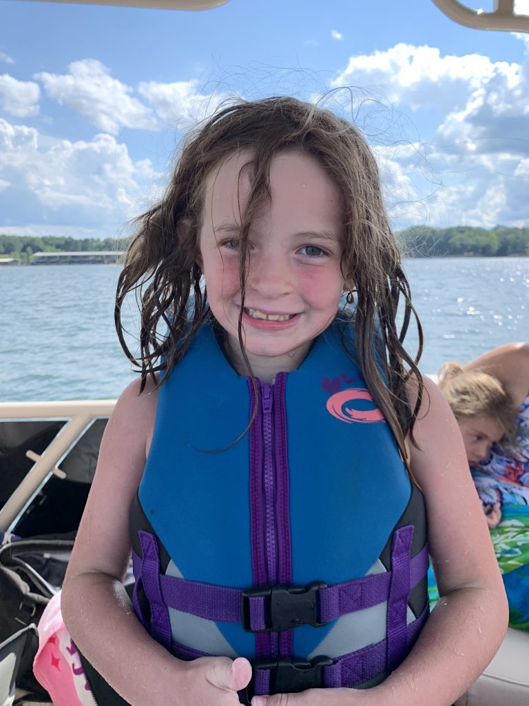 child smiling in life vest on Lake Ouachita