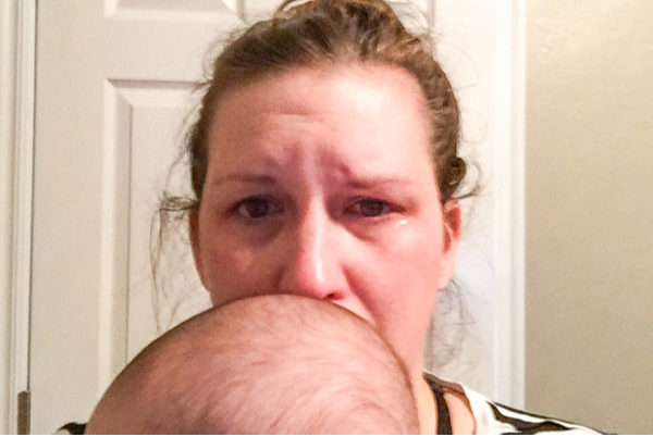 crying mom holding crying baby (grieving the newborn experience)