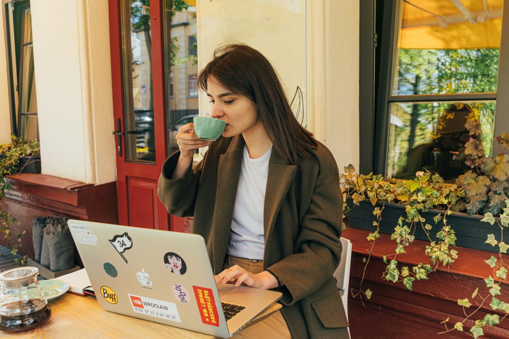 woman on laptop at coffee shop, self care ideas for moms