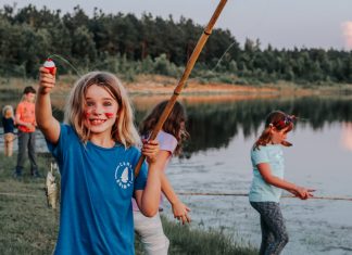happy girl fishing near a lake, Texas sleepaway camps, Camp Huawni