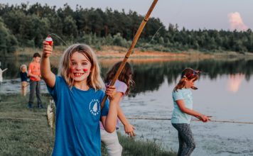 happy girl fishing near a lake, Texas sleepaway camps, Camp Huawni