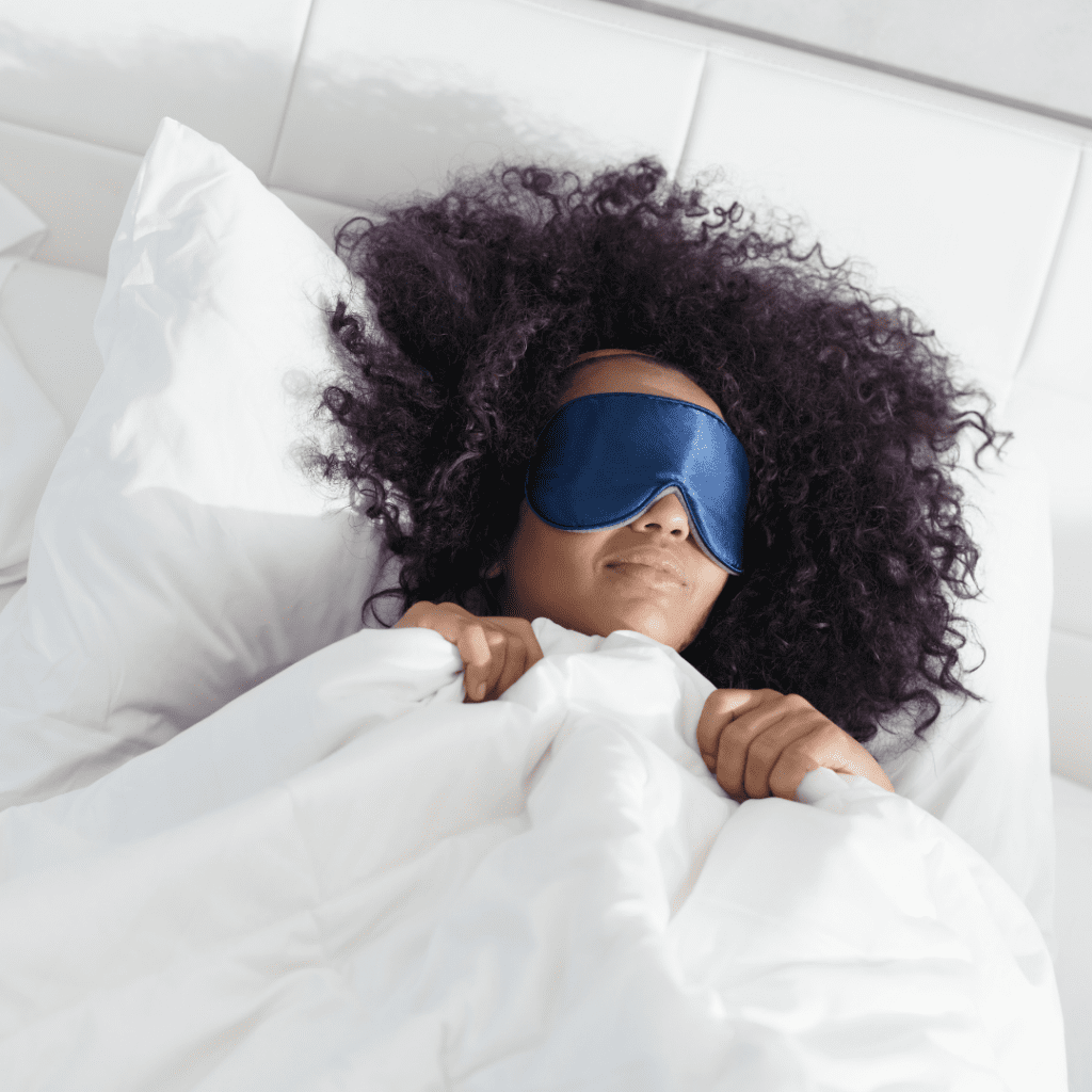 mom in bed with a sleep mask on, sleep tips for parents