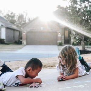 kids chalking driveway, becoming a foster parent in Texas 2022