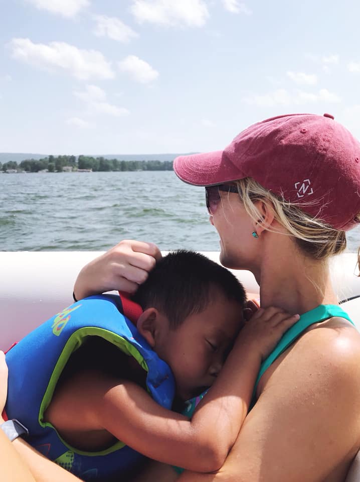 mom on boat holding sleeping child, post-adoption depression story