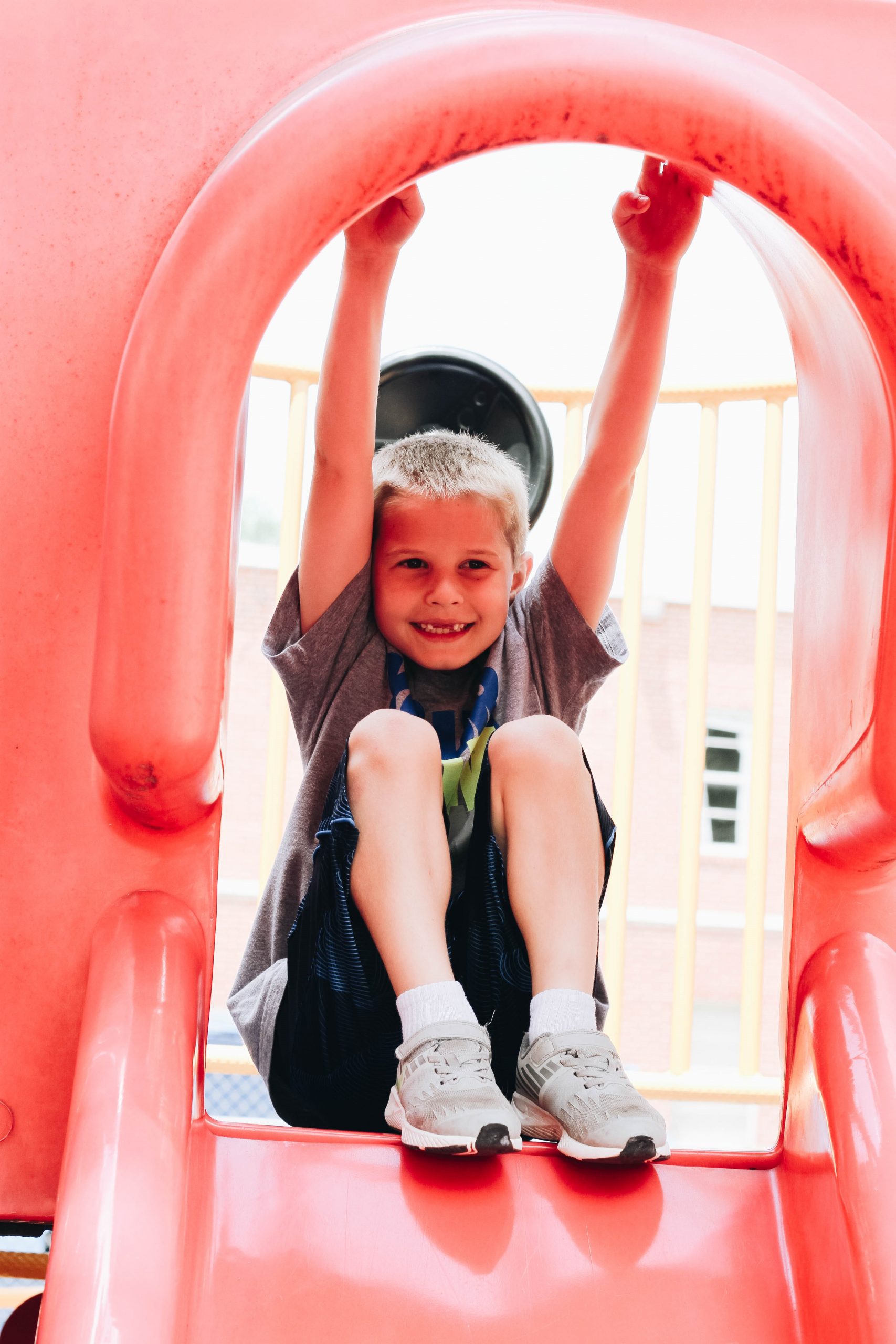 smiling boy at the top of a slide, Lionheart Children's Academy