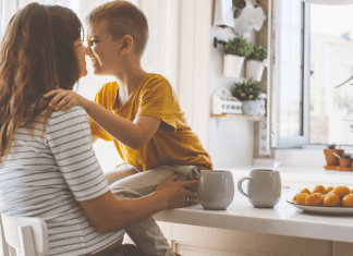 pregnant woman about to hug young son sitting on kitchen counter, military mindset parenting