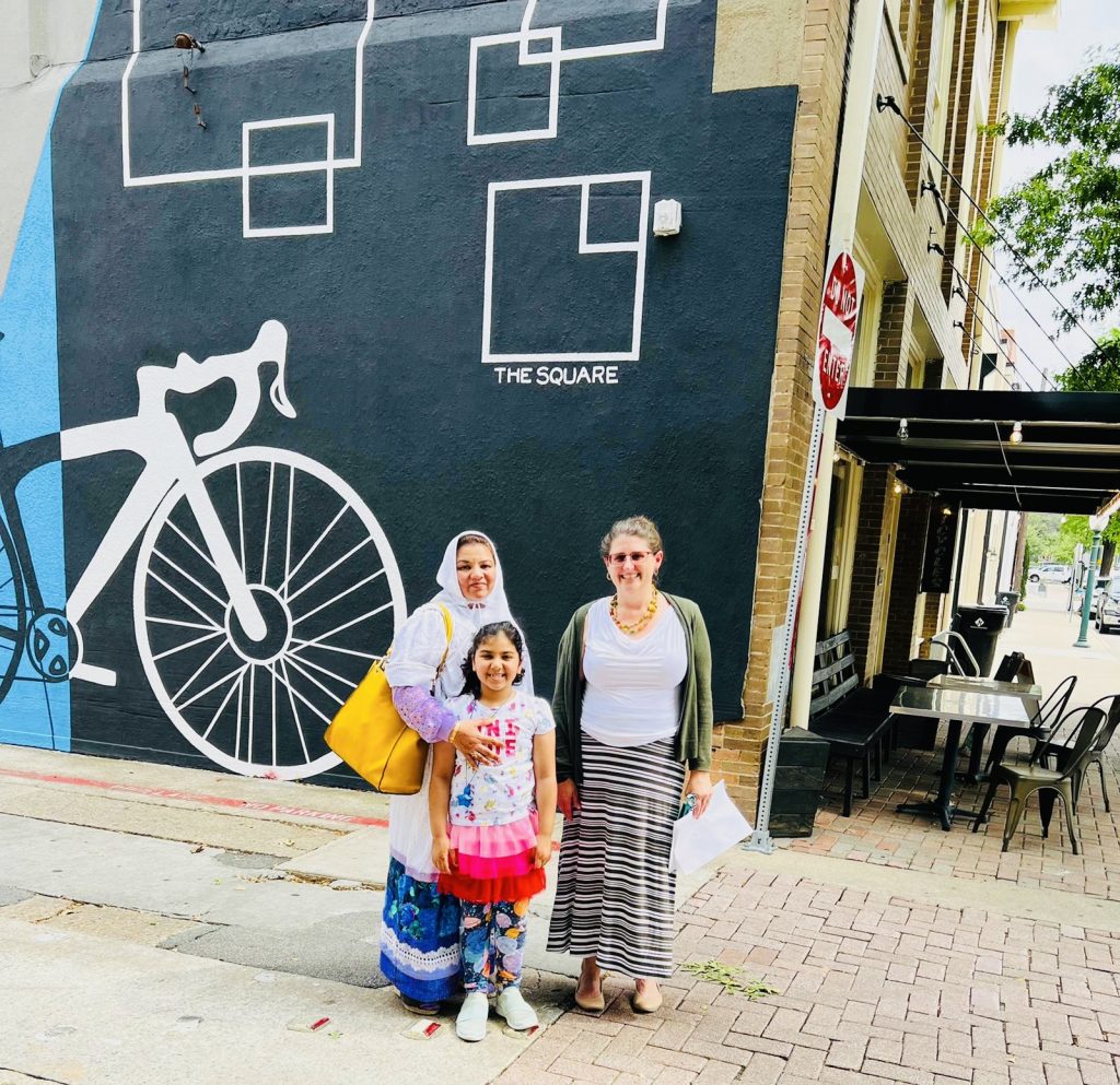 family posing in front of mural on downtown mckinney tours