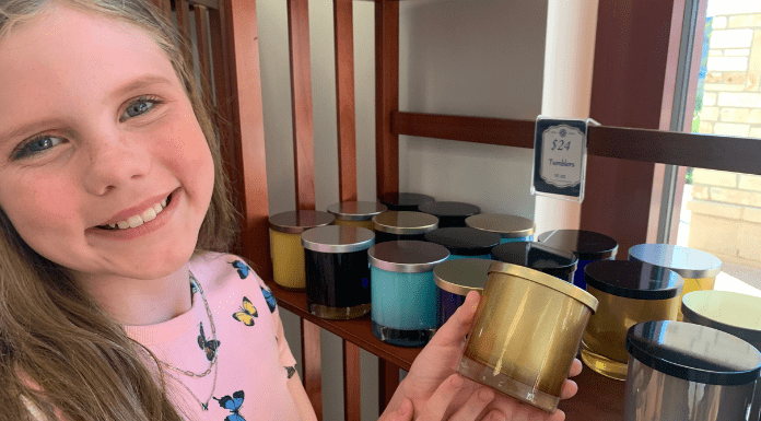 girl smiling and holding a candle at Rocky Creek Candle Company
