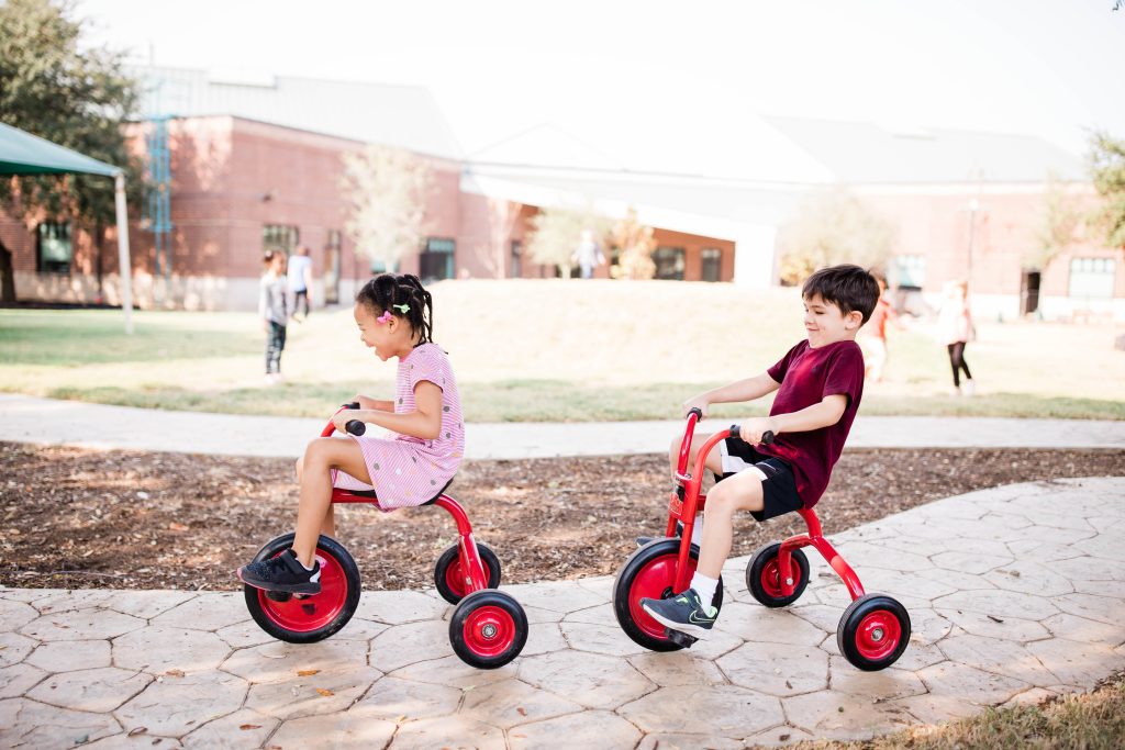 kids riding tricycles at Pebblecreek Montessori