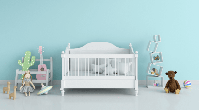 A crib in a blue room is a newborn essential.