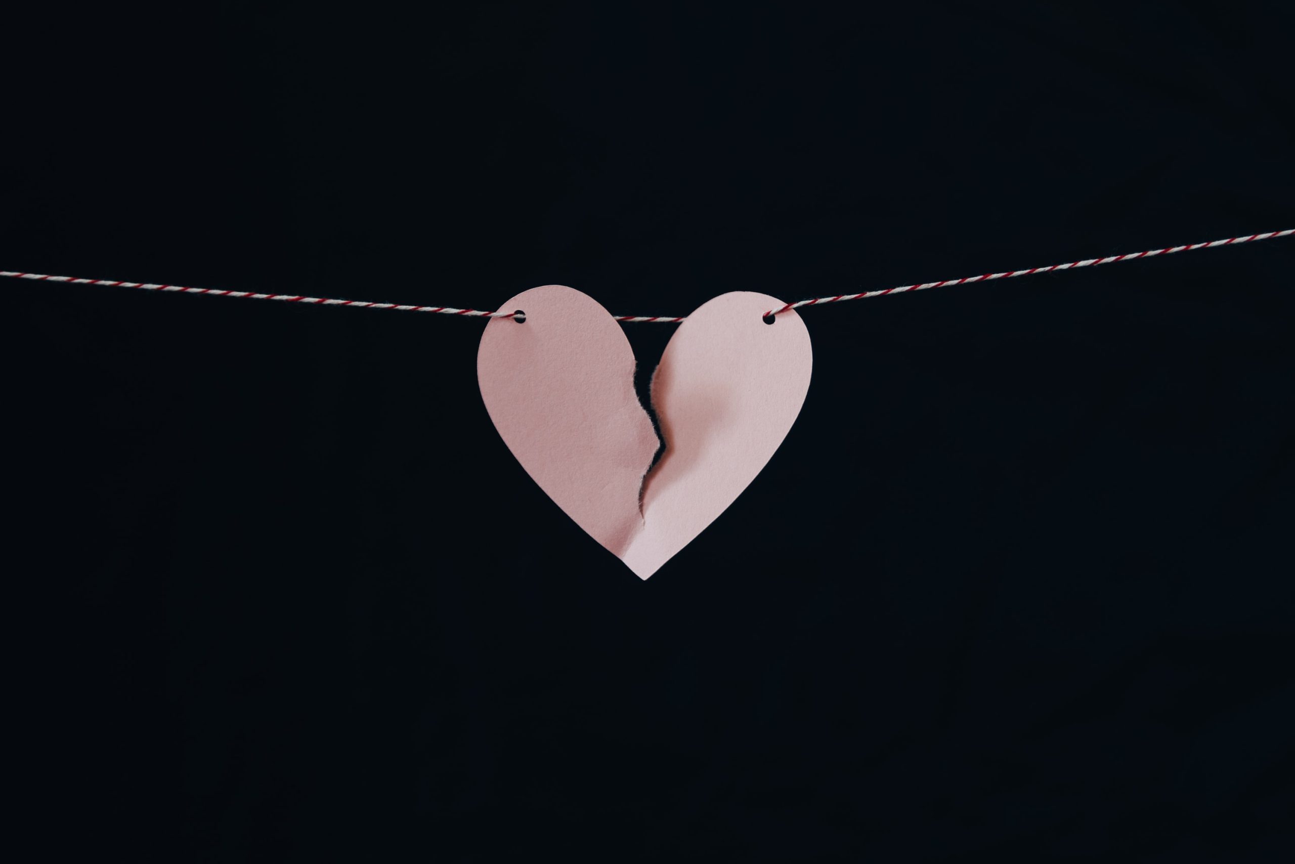 A paper heart on a string starts to rip.
