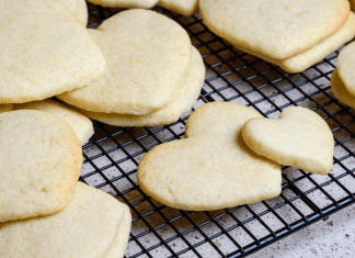 Cookies shaped like hearts cool on a baking rack.