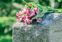 Flowers rest on top of a headstone.