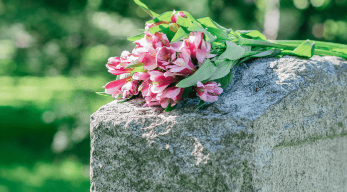 Flowers rest on top of a headstone.