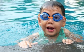 Young child with goggles swimming