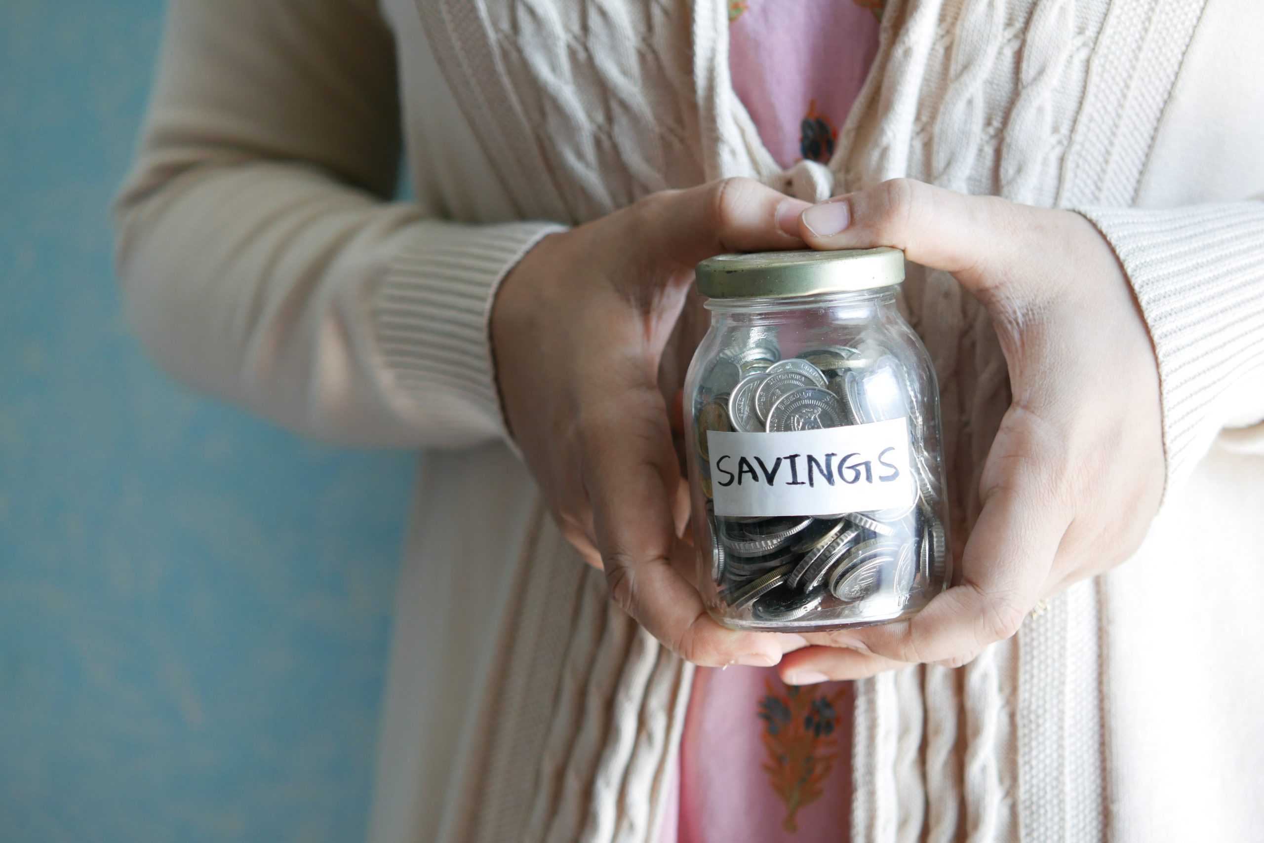 A woman holding a jar of coins.