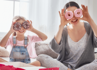 A mom and daughter put donuts on their eyes.