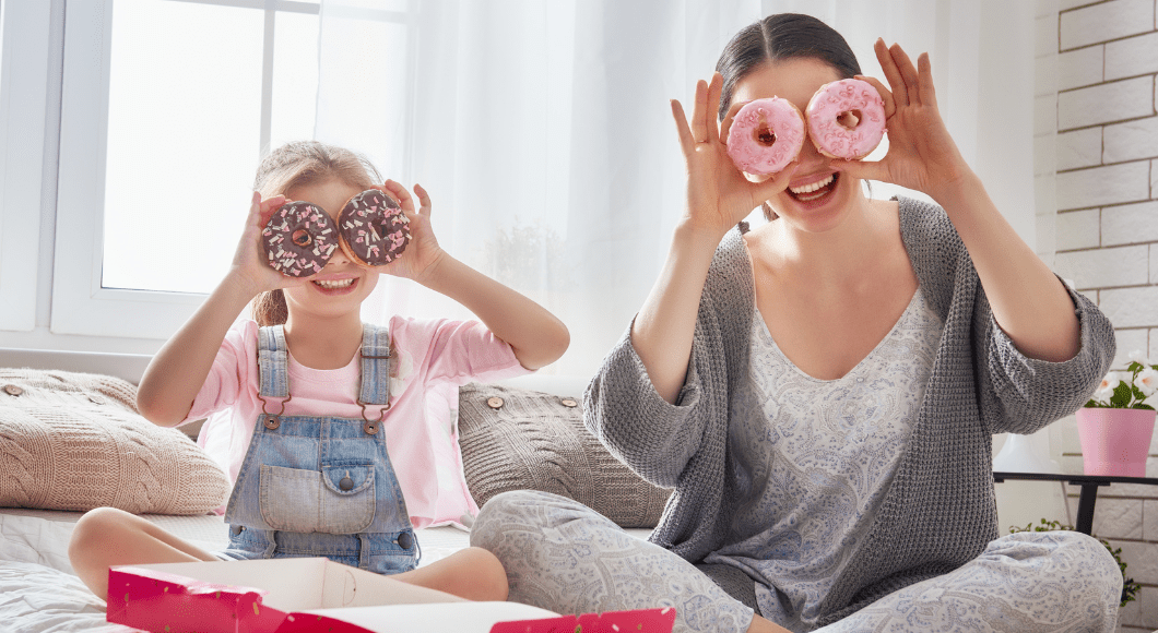 A mom and daughter put donuts on their eyes.