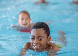 Kids swim in a pool.