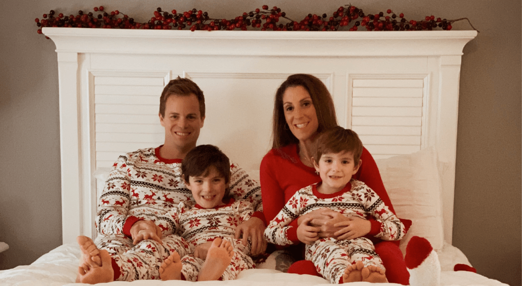 family in holiday pajamas on bed