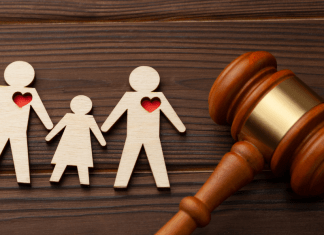 A wooden cutout of a family with red hearts, and a gavel.