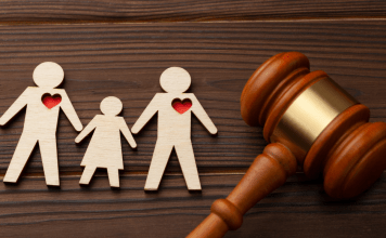 A wooden cutout of a family with red hearts, and a gavel.
