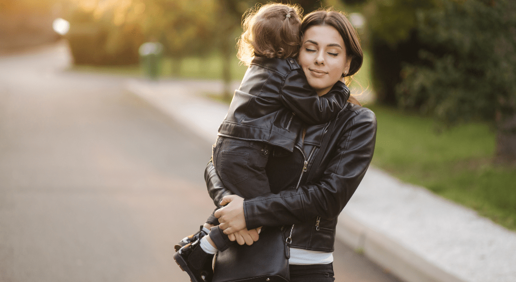 Mother and child hugging in matching leather jackets