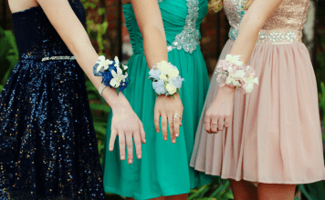 Trio of girls show off prom corsages on their wrists.