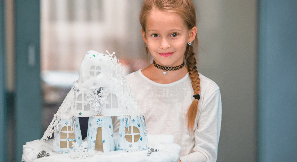 A little girl with a braid like Elsa's shows an ice castle she built out of cups.